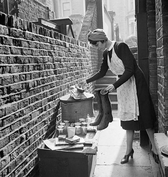 A British housewife puts out items for salvage during 1942. Ministry of Information Second World War Official Collection